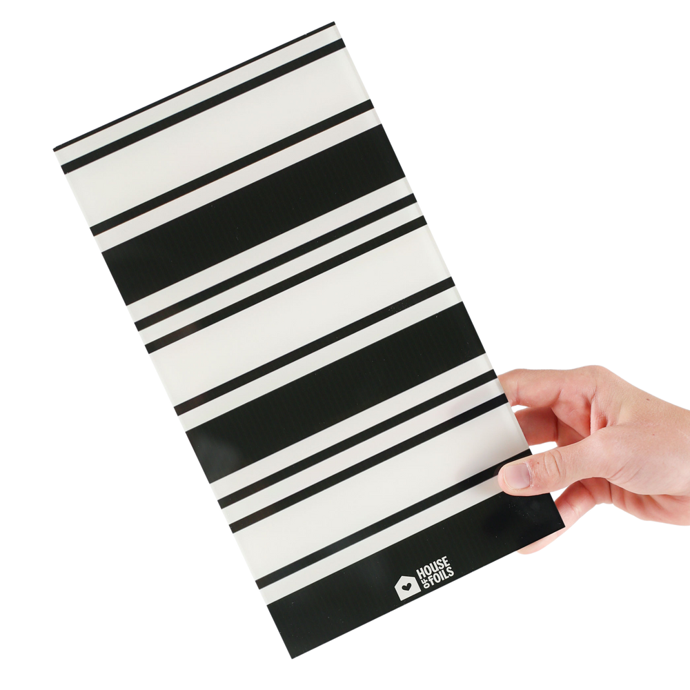 Hand holding the Retro Stripe balayage board in bold black and white stripes