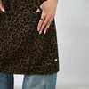 Cheetah print HOF Everyday Apron shown over jeans with the House of Foils heart logo