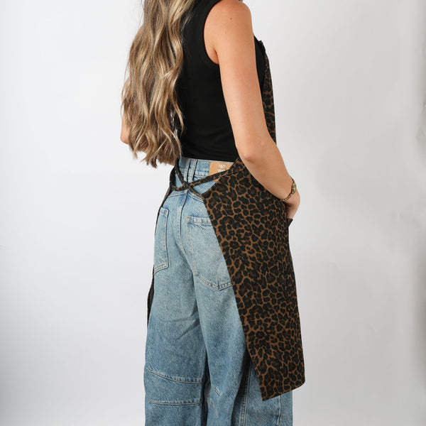 Side view of the cheetah print HOF Everyday Apron worn over jeans