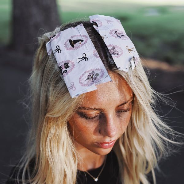 Model wearing Haunted Mansion printed foil sheets in her blonde hair outdoors