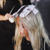 Stylist applying Haunted Mansion foil to a blonde client's hair