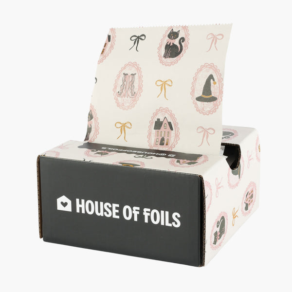 Haunted Mansion 5x11 inch hair foil in cream with black cats and witch hats, shown on a black House of Foils box