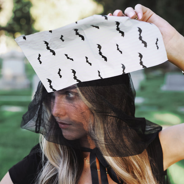 Stylist holding up a sheet of House of Batties black bat print hair foil