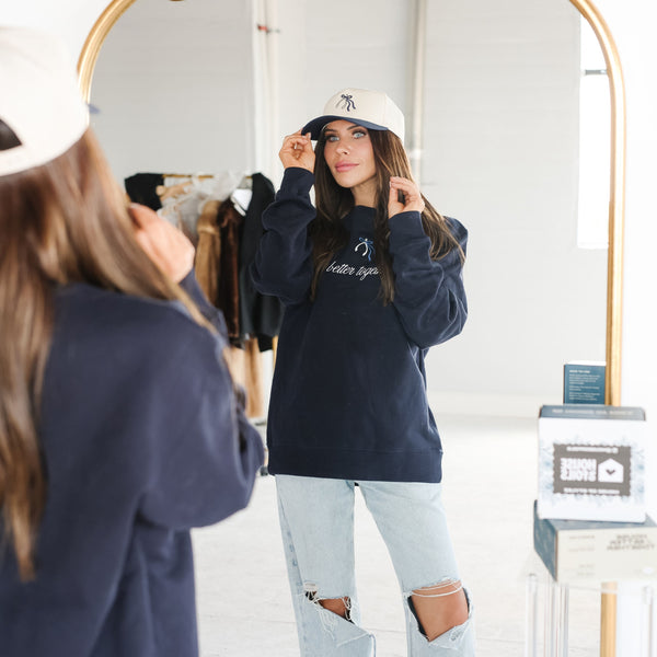 White and navy Wishbone Hat worn by hair stylist in salon